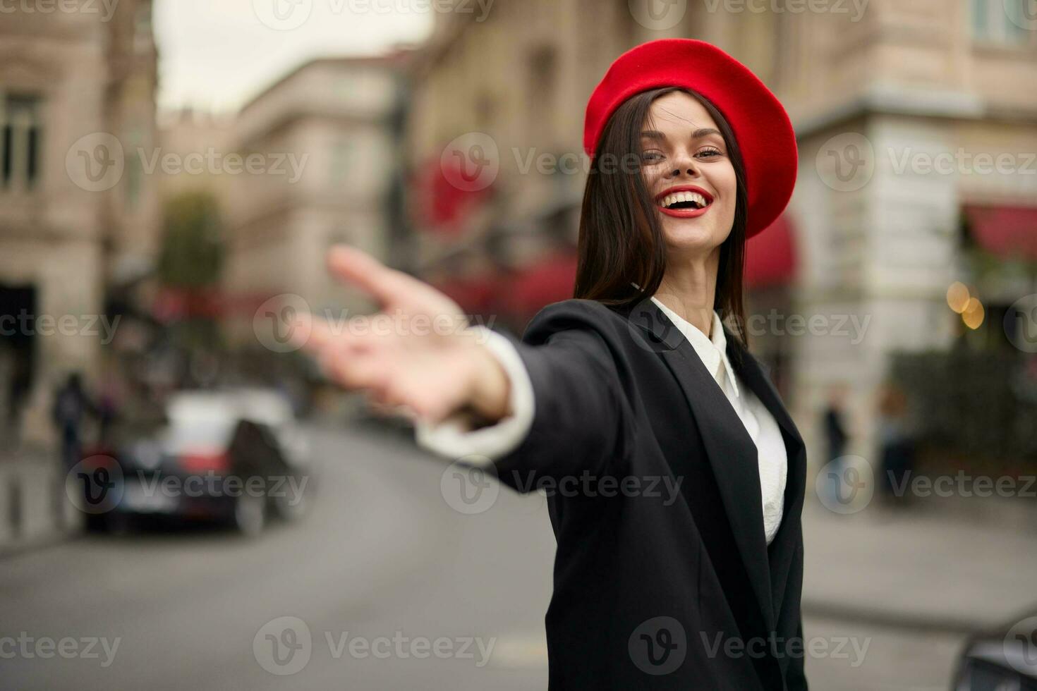 Fashion woman smile with teeth standing on the street in front of the city tourist follow me stylish clothes with red lips and red beret, travel, cinematic color, retro vintage style, urban fashion. photo