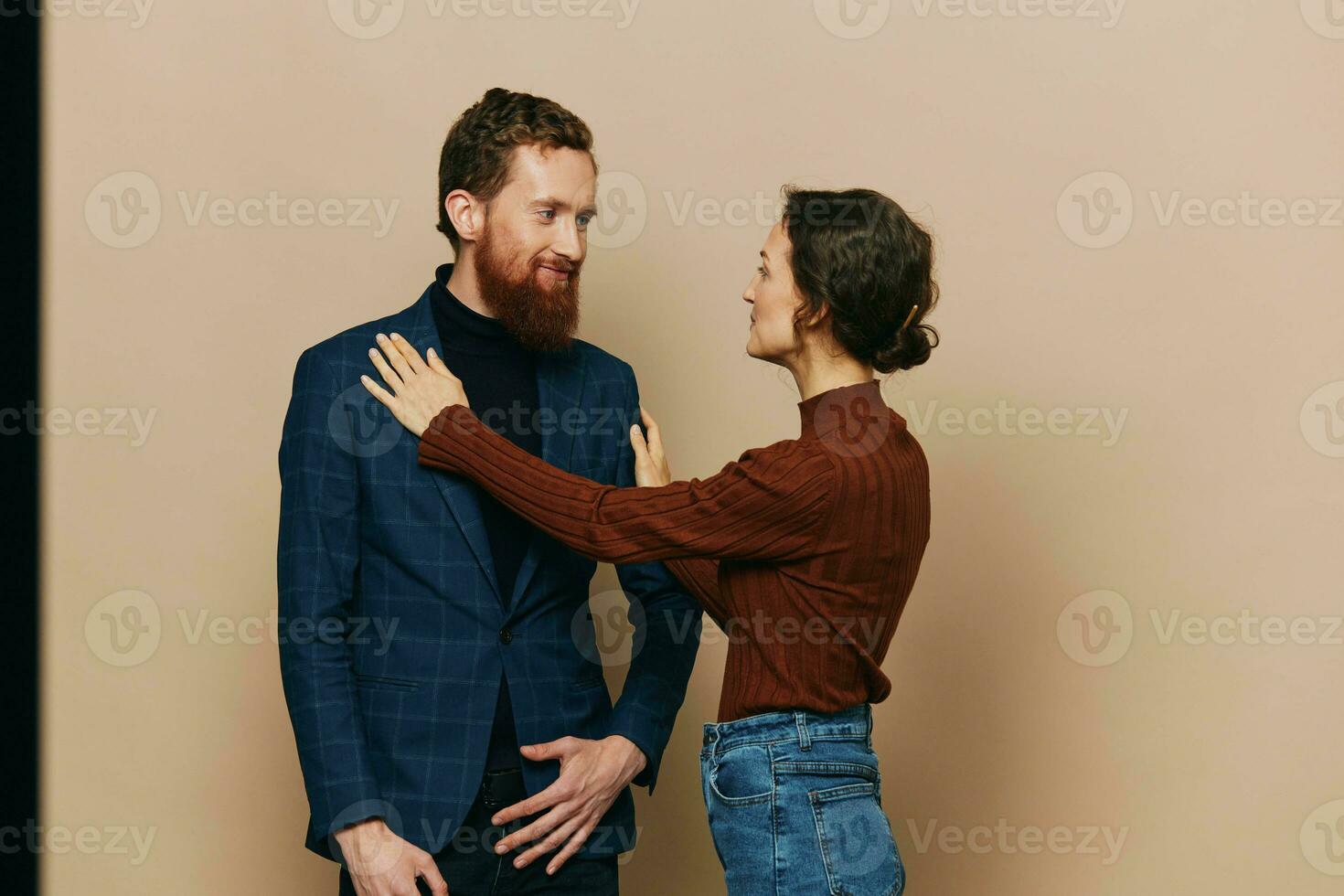 Man and woman couple in a relationship smile and interaction on a beige background in a real relationship between people photo