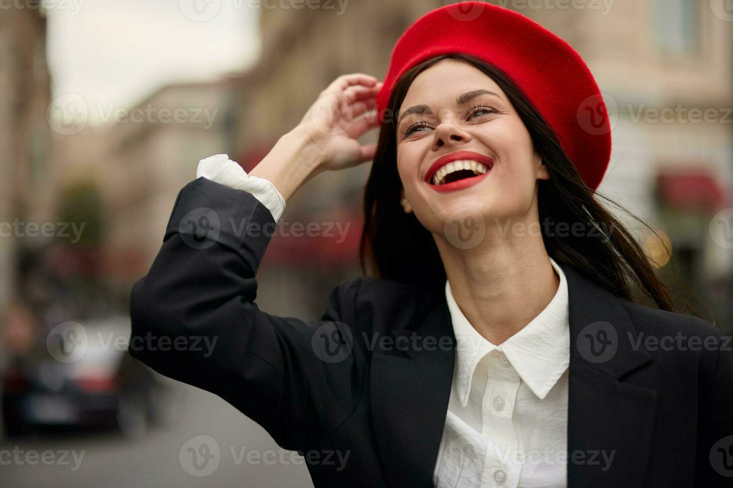 Fashion woman portrait smile with teeth standing on the street in front of the city tourist in stylish clothes with red lips and red beret, travel, cinematic color, retro vintage style, urban fashion. photo