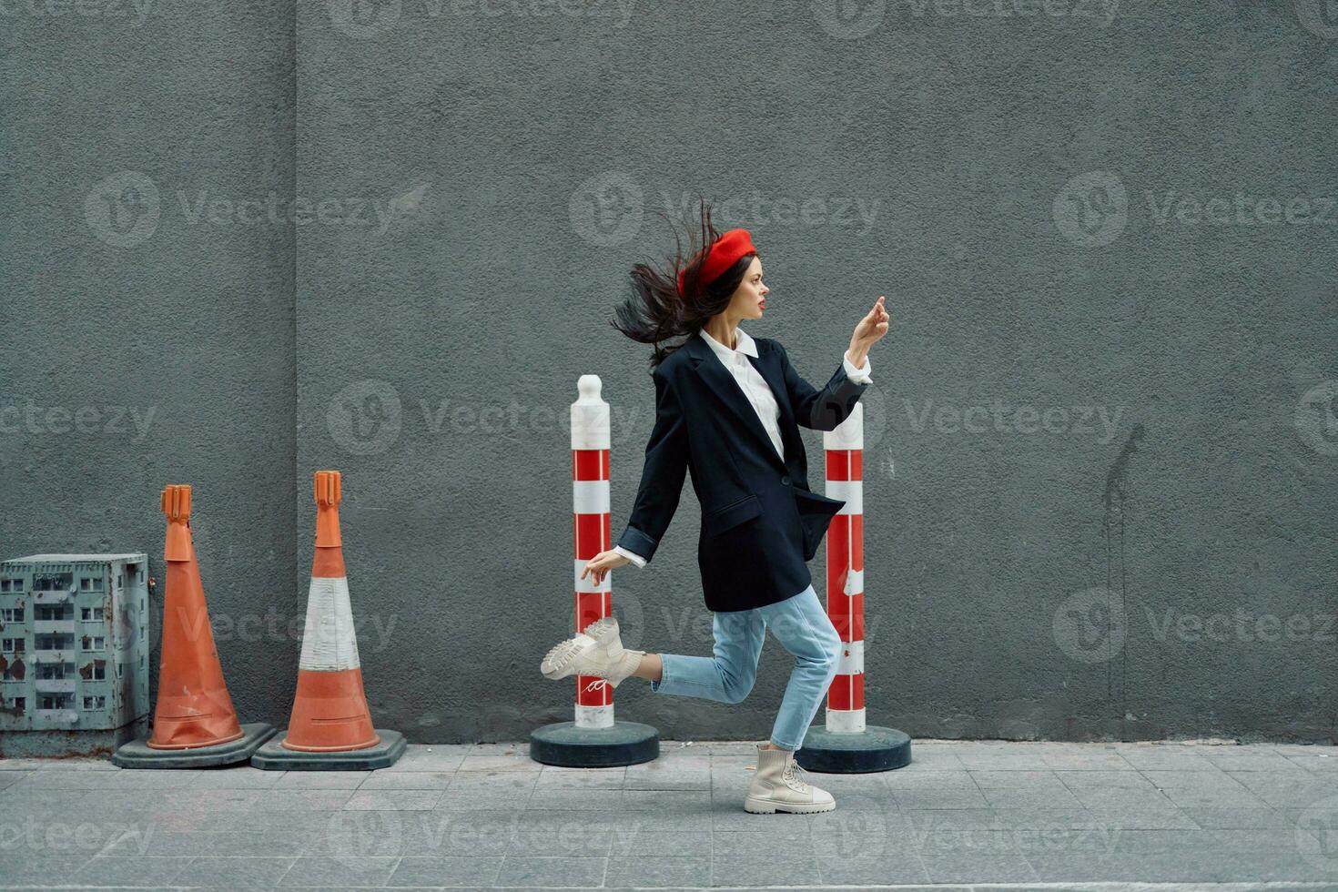 Moda mujer corriendo abajo el calle en frente de el ciudad turista en elegante ropa con rojo labios y rojo boina, viajar, cinematográfico color, retro Clásico estilo, tarde a trabajar. foto