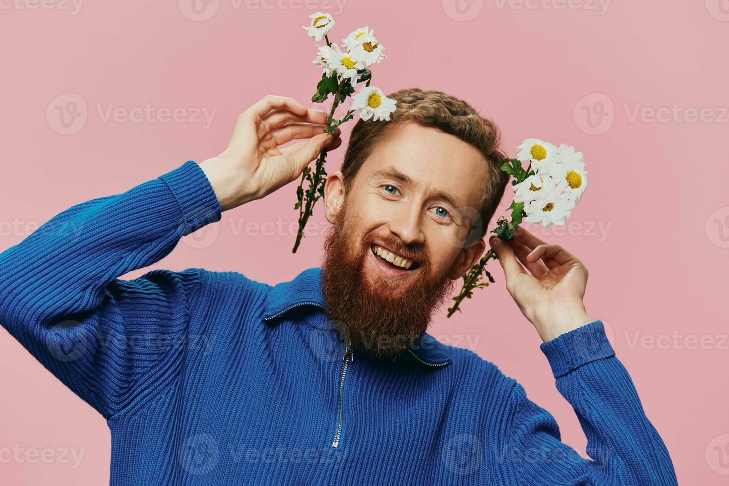 Portrait of a funny man smiling with a bouquet of flowers daisies on pink isolated background, copy place. Holiday concept and congratulations, Valentine's Day, Women's Day. photo