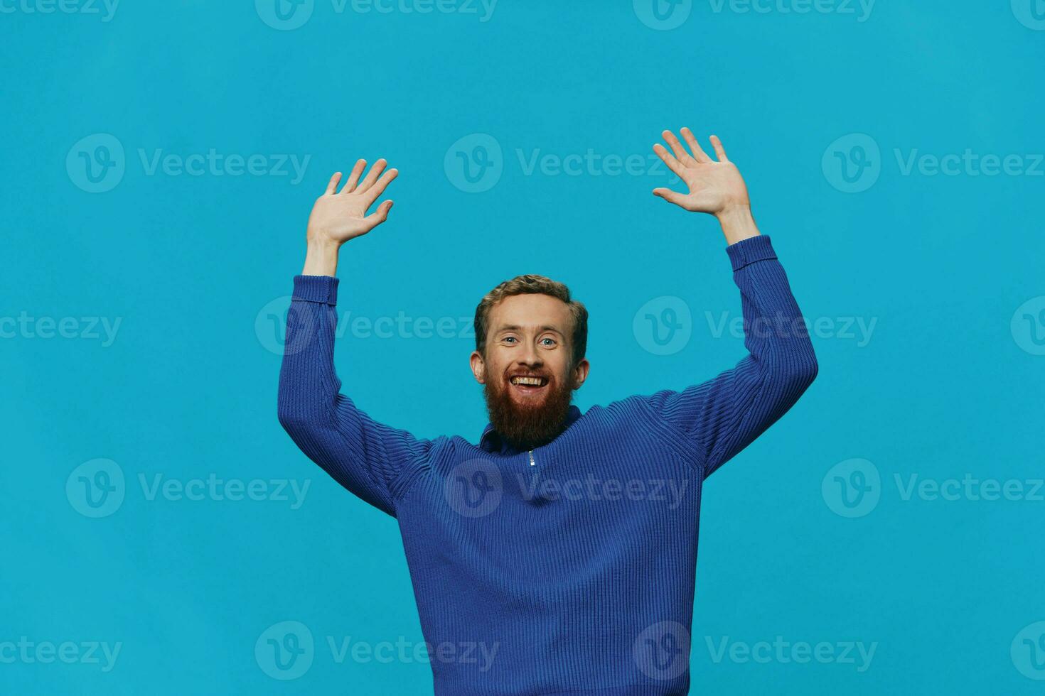 Portrait of a man in a sweater smile and happiness, hand signs and symbols, on a blue background. Lifestyle positive, copy place. photo