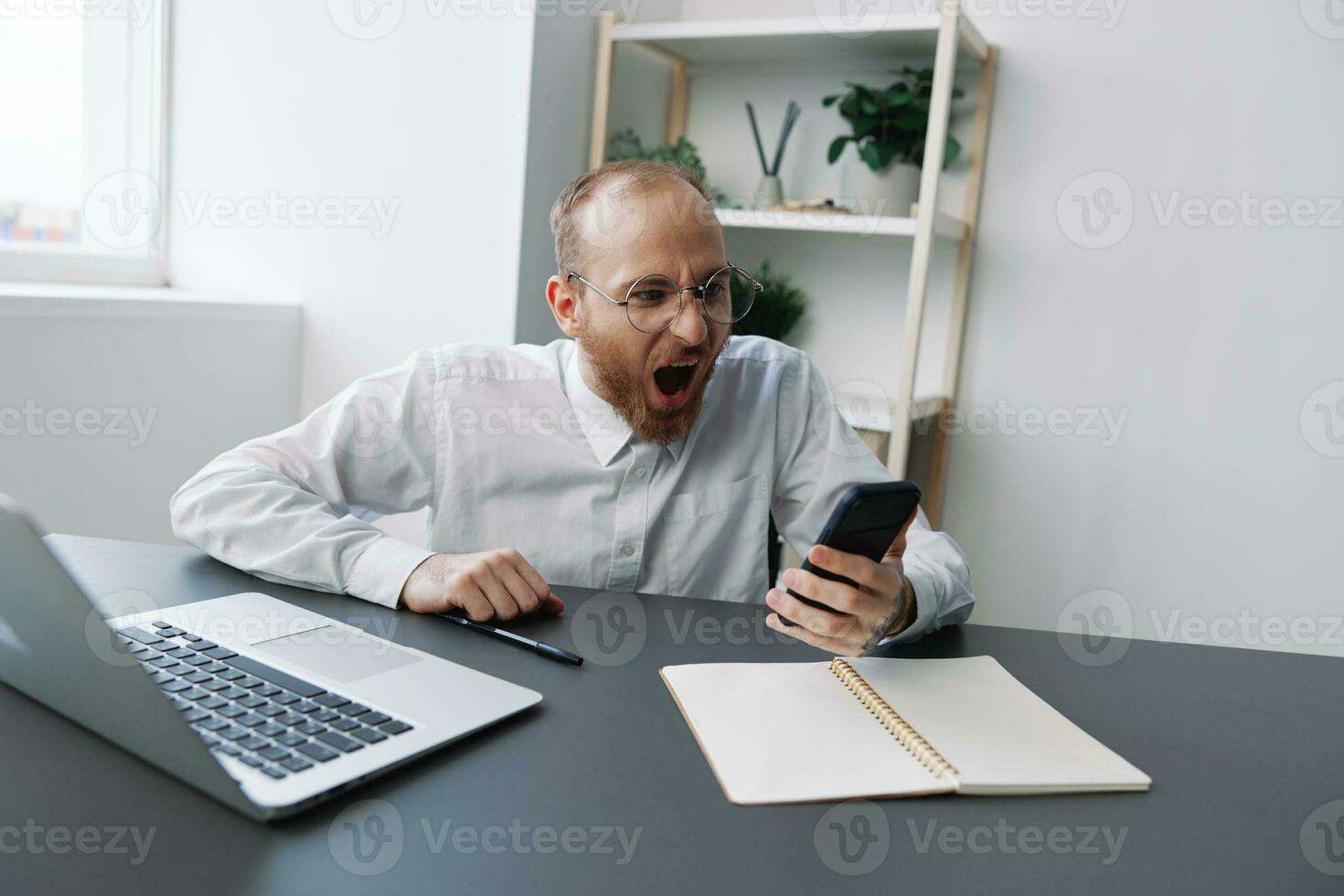 A man in a wheelchair a businessman with tattoos in the office works, talking on the phone screaming and angry, integration into society, the concept of working a person with disabilities photo