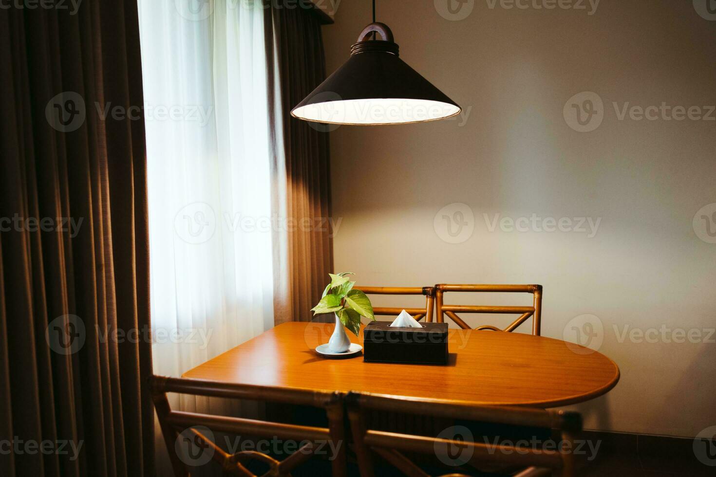 Dark home interior with wood dining table lit by lamp, evening light for dinner. photo