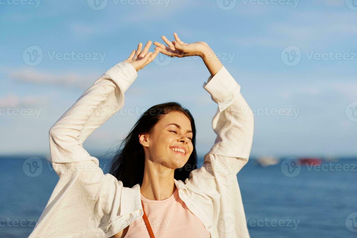 Woman smile with teeth freedom on vacation walking on the beach by the ocean in Bali sunset, happy travel and vacation, sunset light, flying hair photo