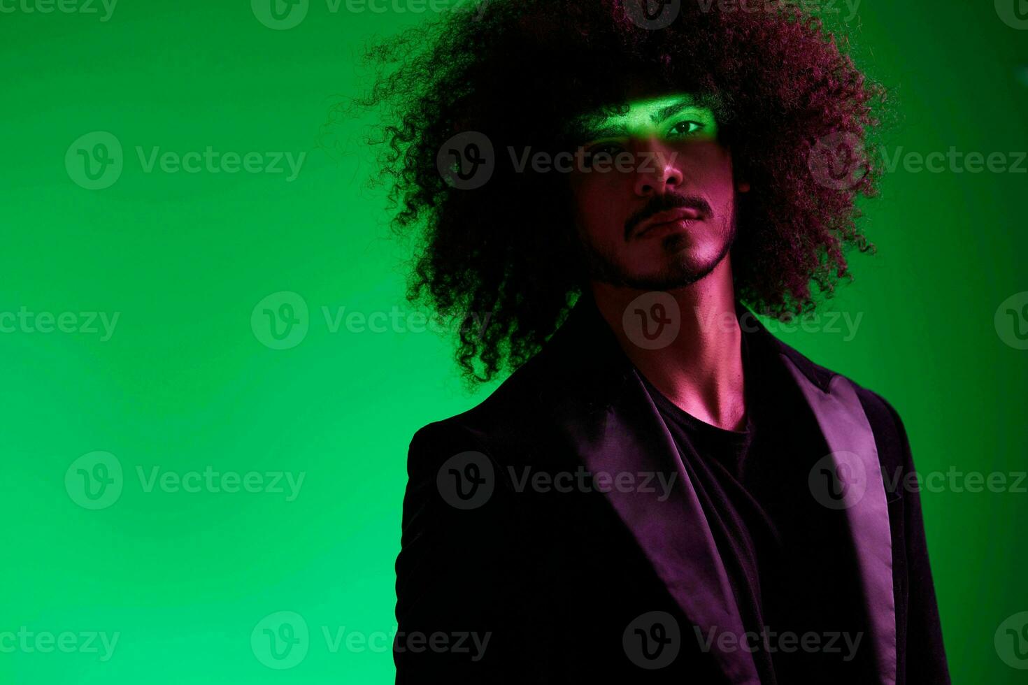 Portrait of a stylish man in a jacket on a green background multinational, color light, trend photo