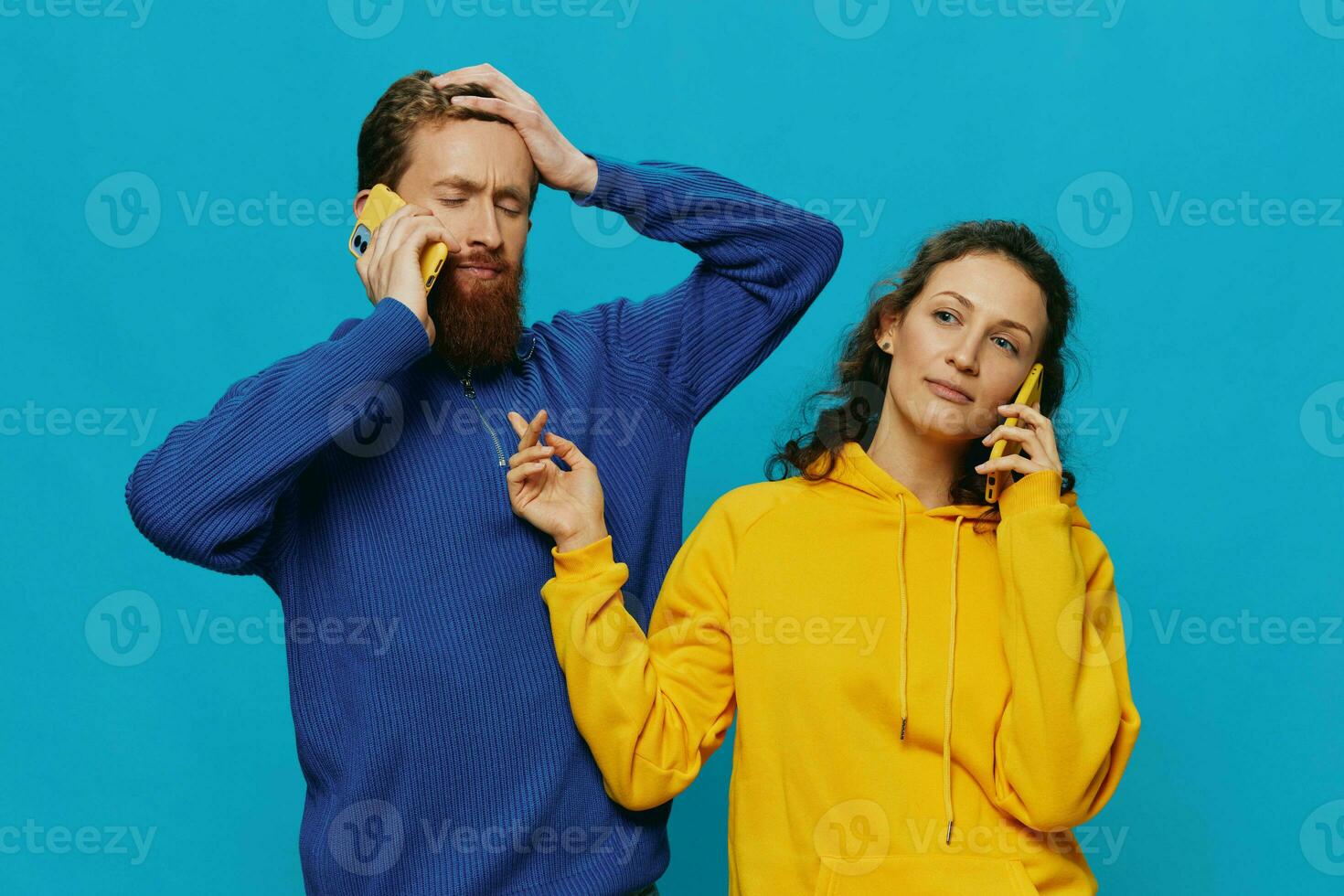 Woman and man cheerful couple with phones in their hands crooked smile cheerful, on blue background. The concept of real family relationships, talking on the phone, work online. photo