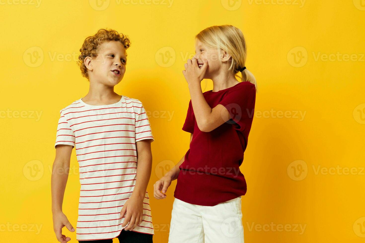 dos alegre niños en pie lado por lado posando infancia emociones aislado antecedentes foto