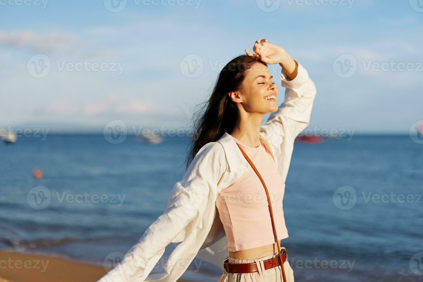 Woman smile freedom on vacation walking on the beach by the ocean in Bali sunset, happy travel and vacation, sunset light photo