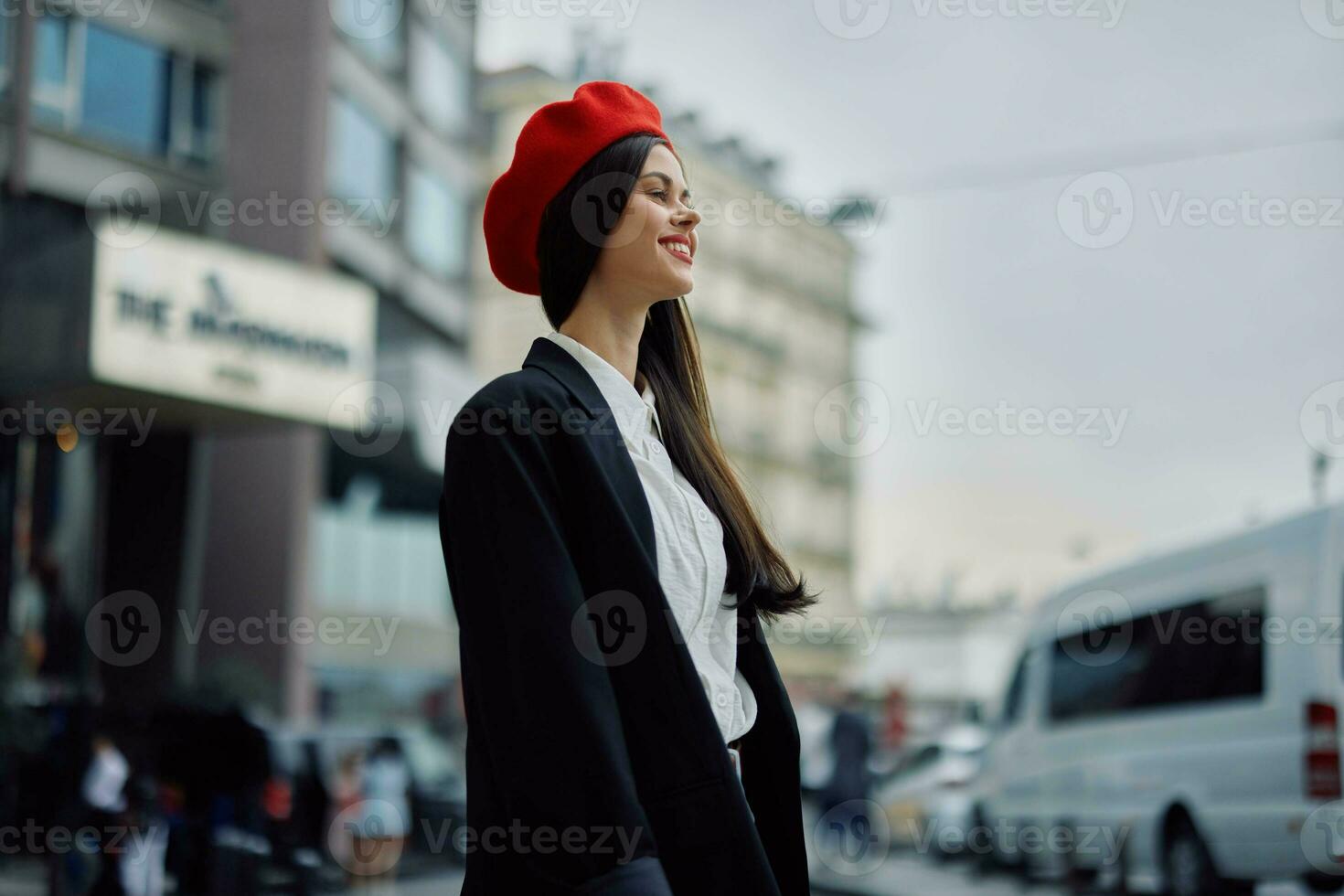 A business woman walks in the city against the backdrop of office buildings, stylish fashionable clothes and make-up, spring walk, travel. photo