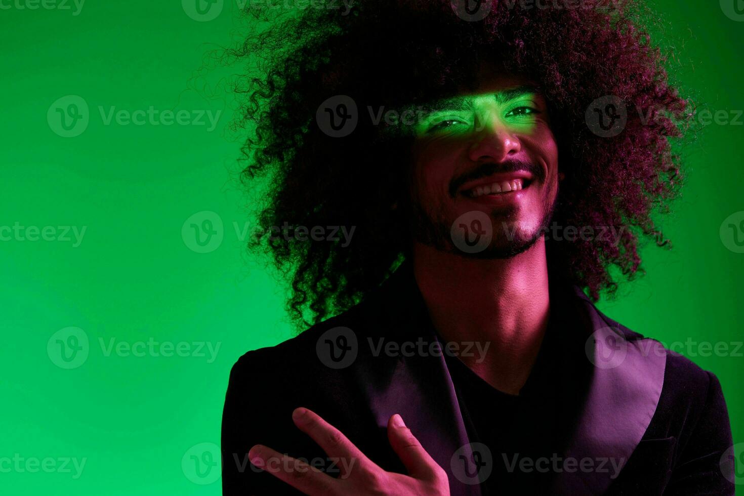 Portrait of a stylish man in a jacket on a green background multinational, color light, trend photo
