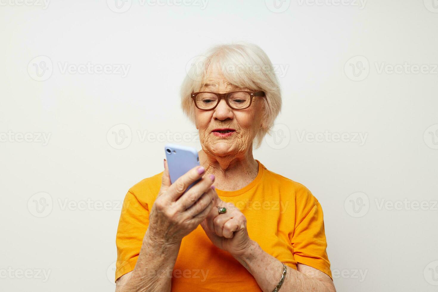 smiling elderly woman in a yellow t-shirt posing communication by phone close-up emotions photo