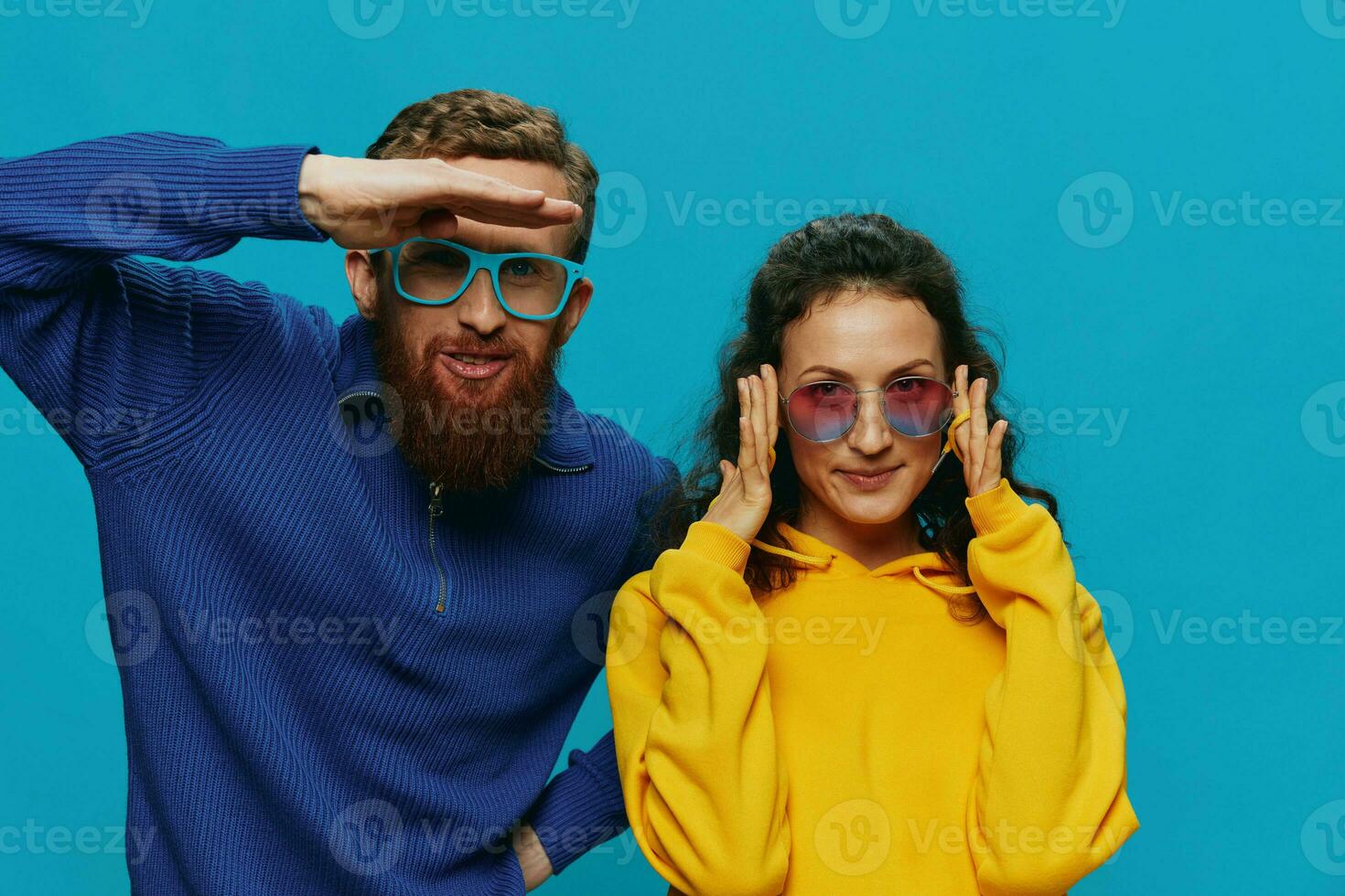 A woman and a man fun couple cranking and showing signs with their hands smiling cheerfully, on a blue background, The concept of a real relationship in a family. photo