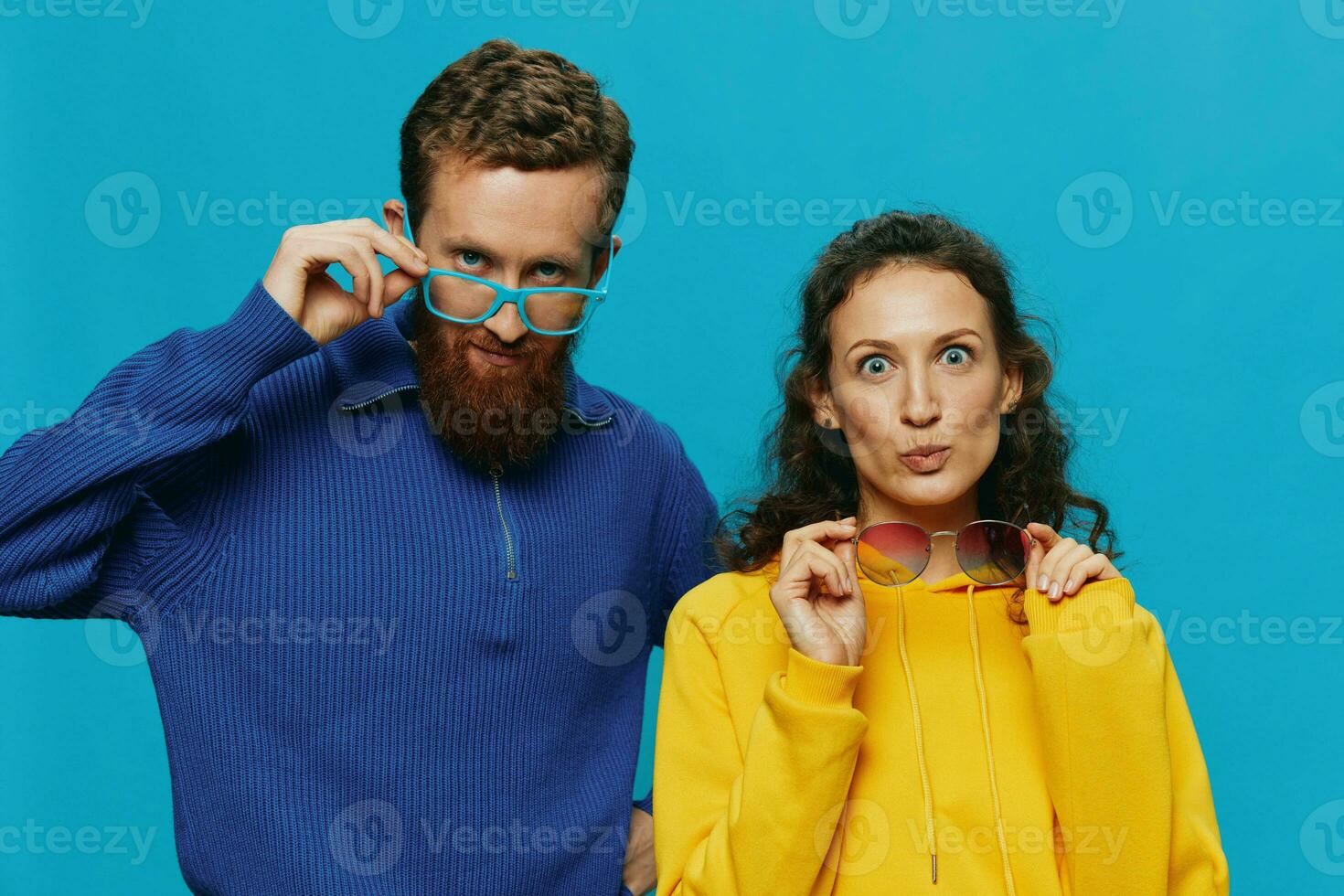 A woman and a man fun couple cranking and showing signs with their hands smiling cheerfully, on a blue background, The concept of a real relationship in a family. photo