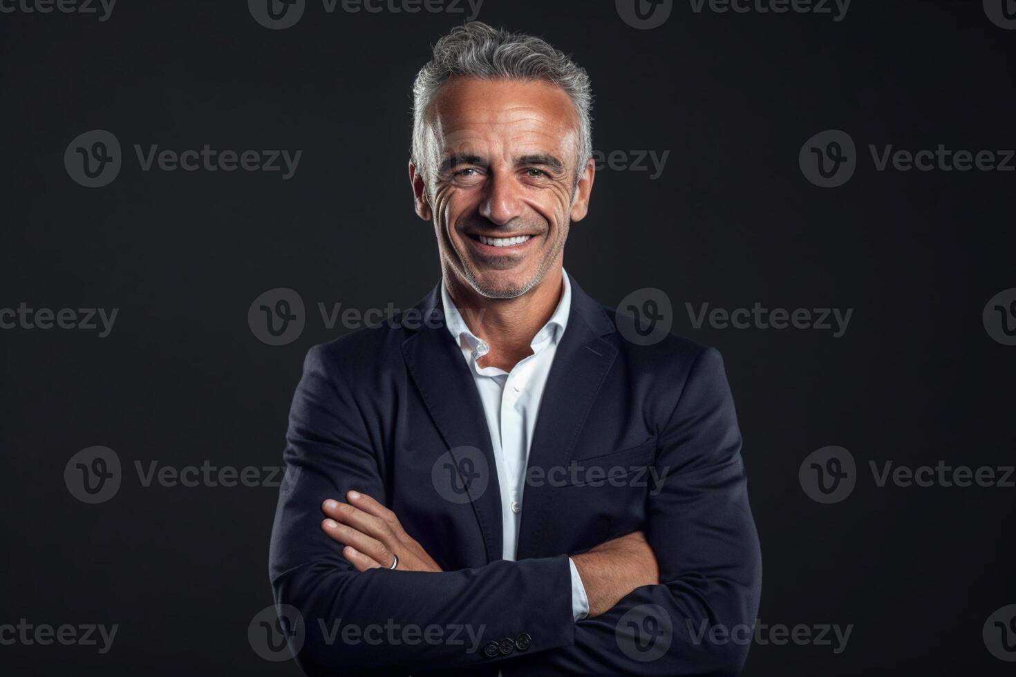 Smiling businessman on the black background with arms crossed photo