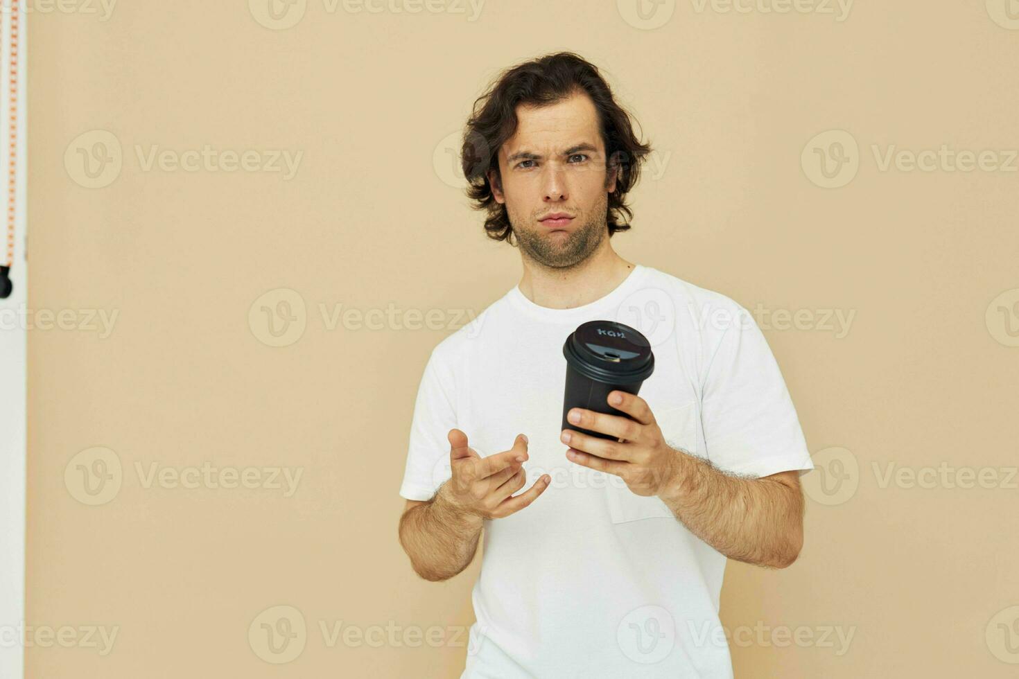 alegre hombre con un negro vaso en un blanco camiseta aislado antecedentes foto
