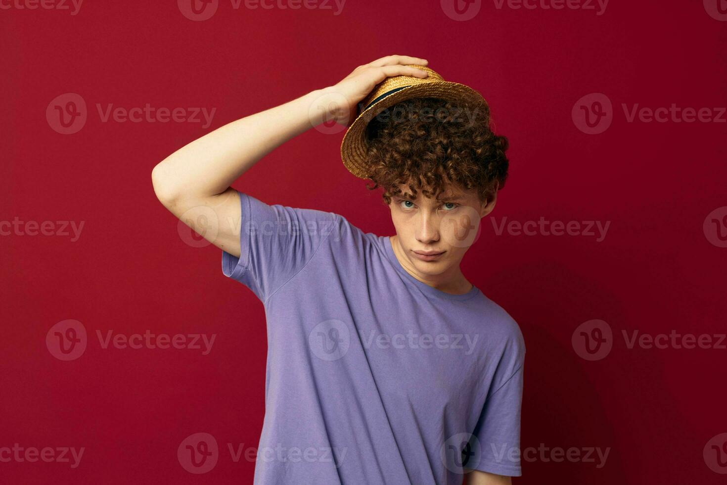 teenager in Hat purple t-shirts posing emotions red background unaltered photo