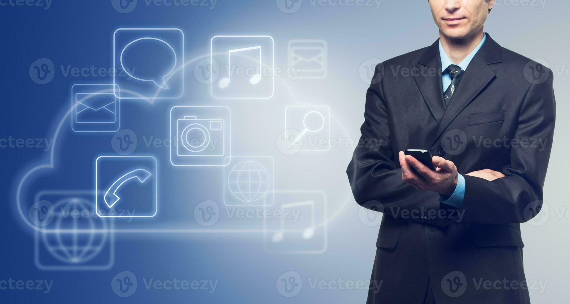 Businessman with touch screen phone and the cloud with applications icons on blue photo