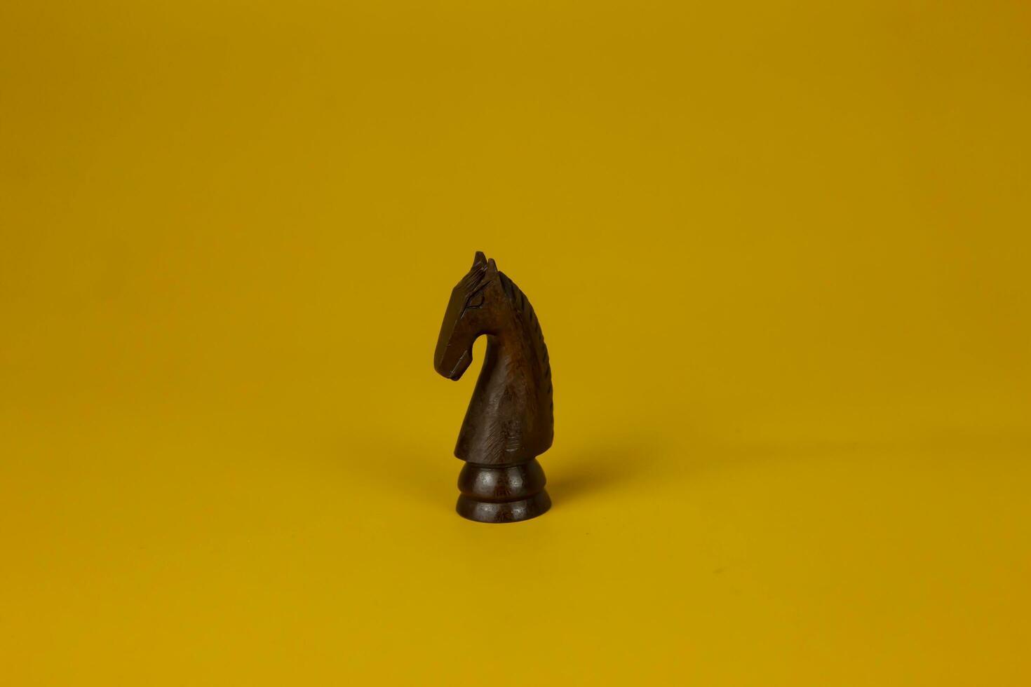 The power of wooden Chess horse piece  isolated yellow background, used for success and stategy concept photo