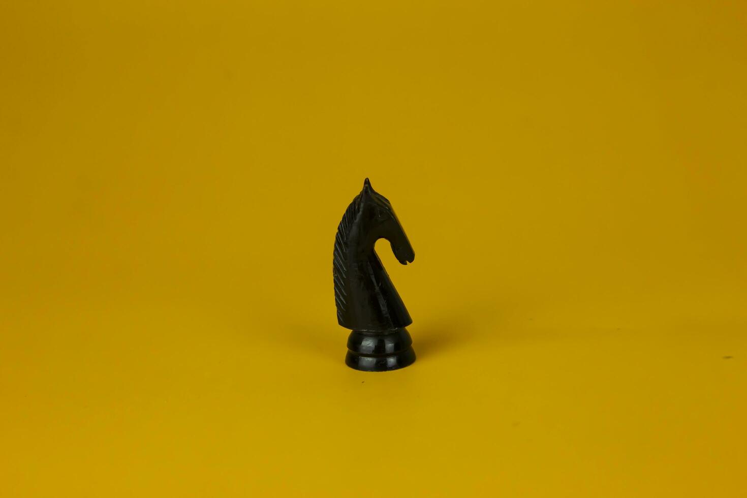 A black horse Chess standing for facing to problem on business on  isolated yellow background, used for success and stategy concept photo