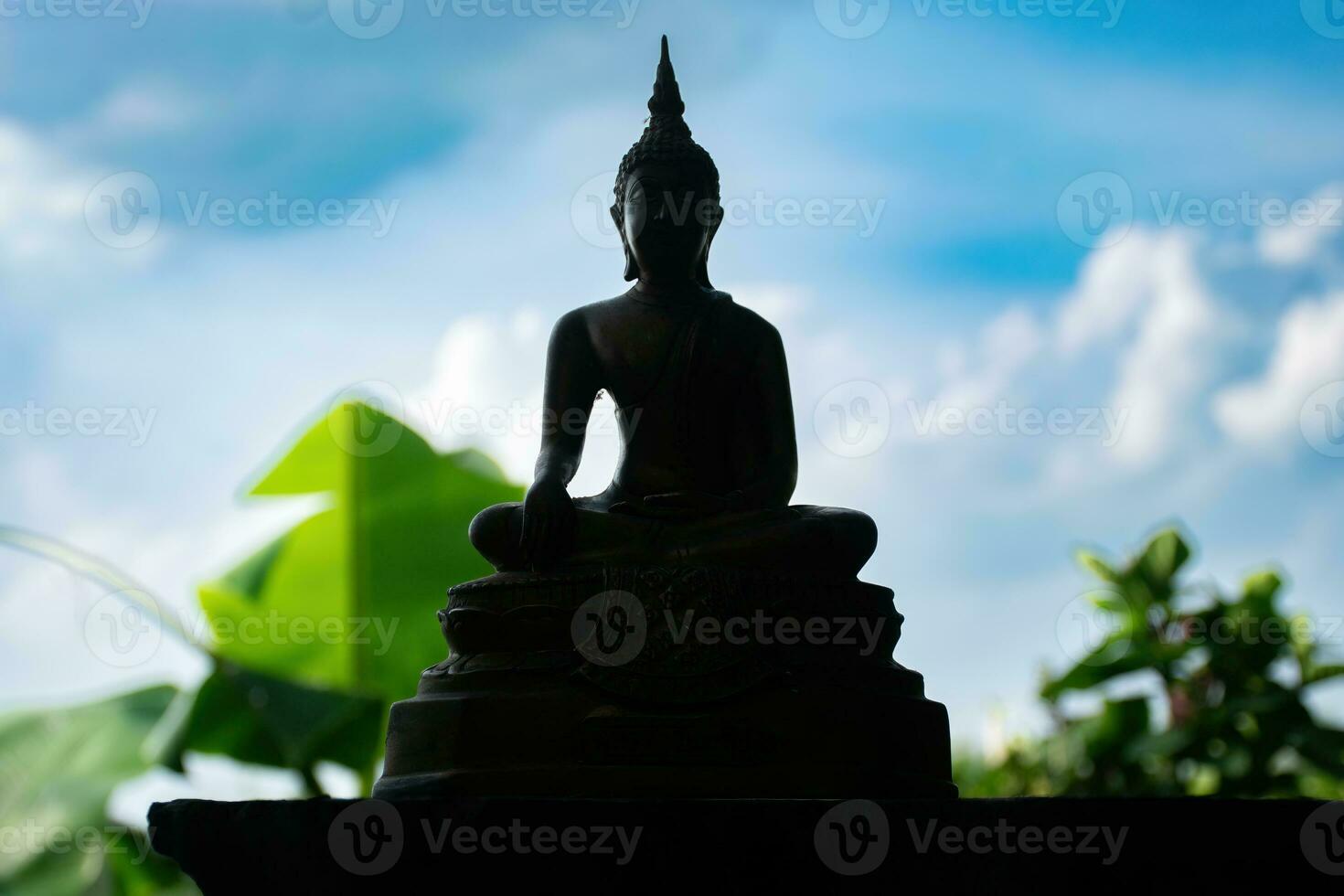 Buddha statue on sunset background,buddha silhouette on blue sunset background photo