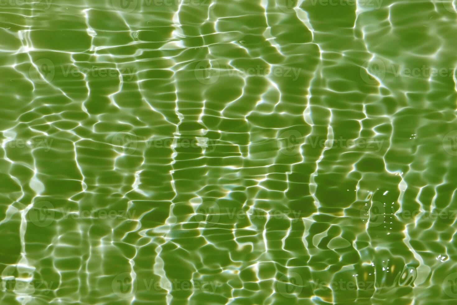 Blue water with ripples on the surface. Defocus blurred transparent blue colored clear calm water surface texture with splashes and bubbles. Water waves with shining pattern texture background. photo
