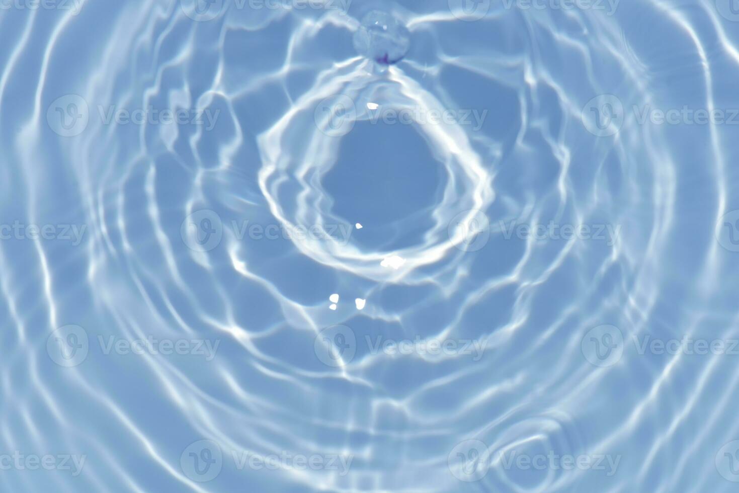 Blue water with ripples on the surface. Defocus blurred transparent blue colored clear calm water surface texture with splashes and bubbles. Water waves with shining pattern texture background. photo