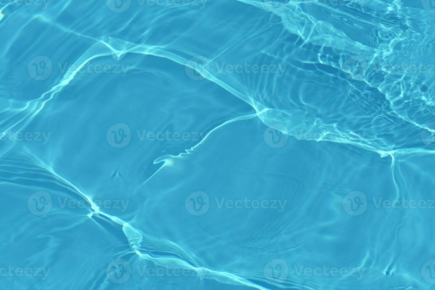 Blue water with ripples on the surface. Defocus blurred transparent blue colored clear calm water surface texture with splashes and bubbles. Water waves with shining pattern texture background. photo