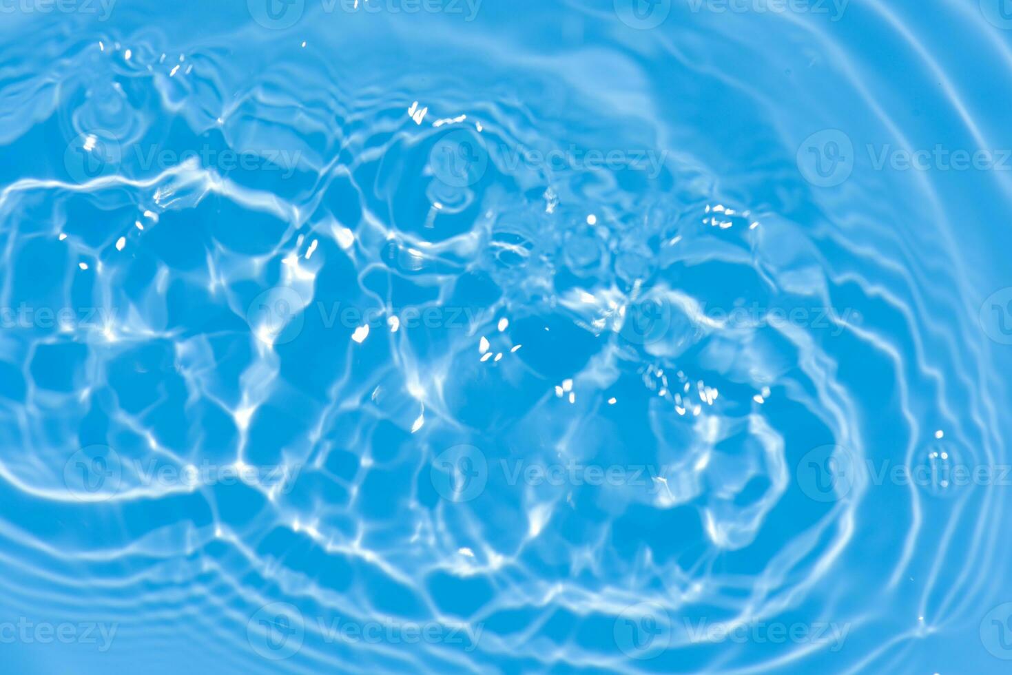 Blue water with ripples on the surface. Defocus blurred transparent blue colored clear calm water surface texture with splashes and bubbles. Water waves with shining pattern texture background. photo