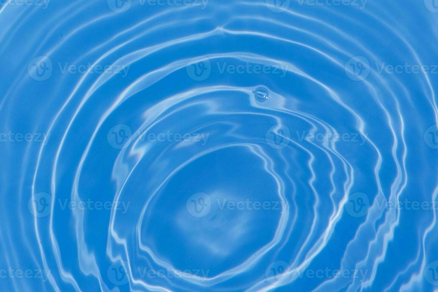 Blue water with ripples on the surface. Defocus blurred transparent blue colored clear calm water surface texture with splashes and bubbles. Water waves with shining pattern texture background. photo