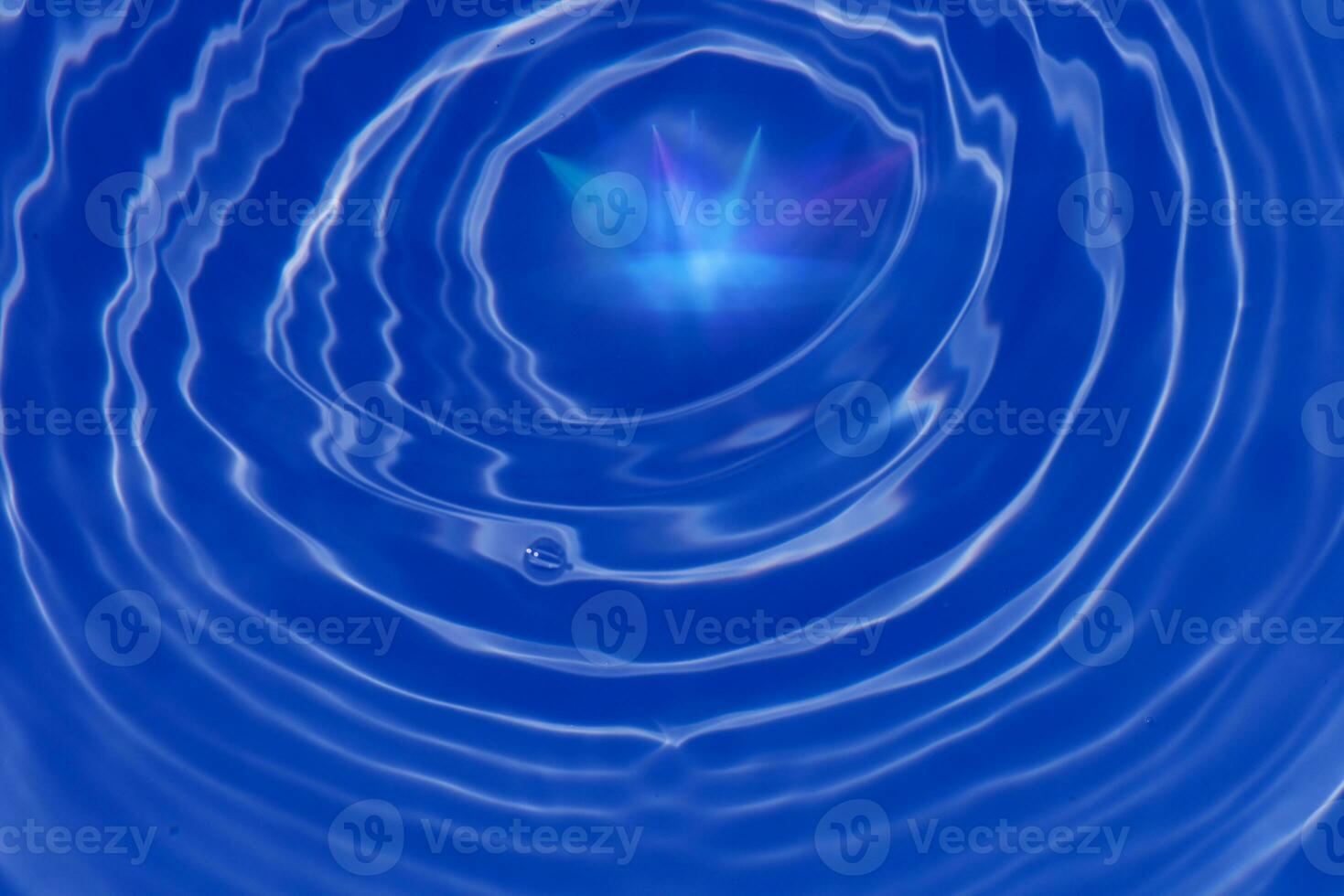 Blue water with ripples on the surface. Defocus blurred transparent blue colored clear calm water surface texture with splashes and bubbles. Water waves with shining pattern texture background. photo