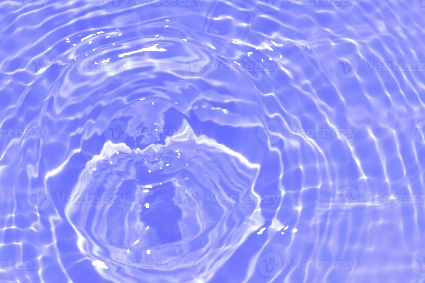 Purple water with ripples on the surface. Defocus blurred transparent pink colored clear calm water surface texture with splashes and bubbles. Water waves with shining pattern texture background. photo