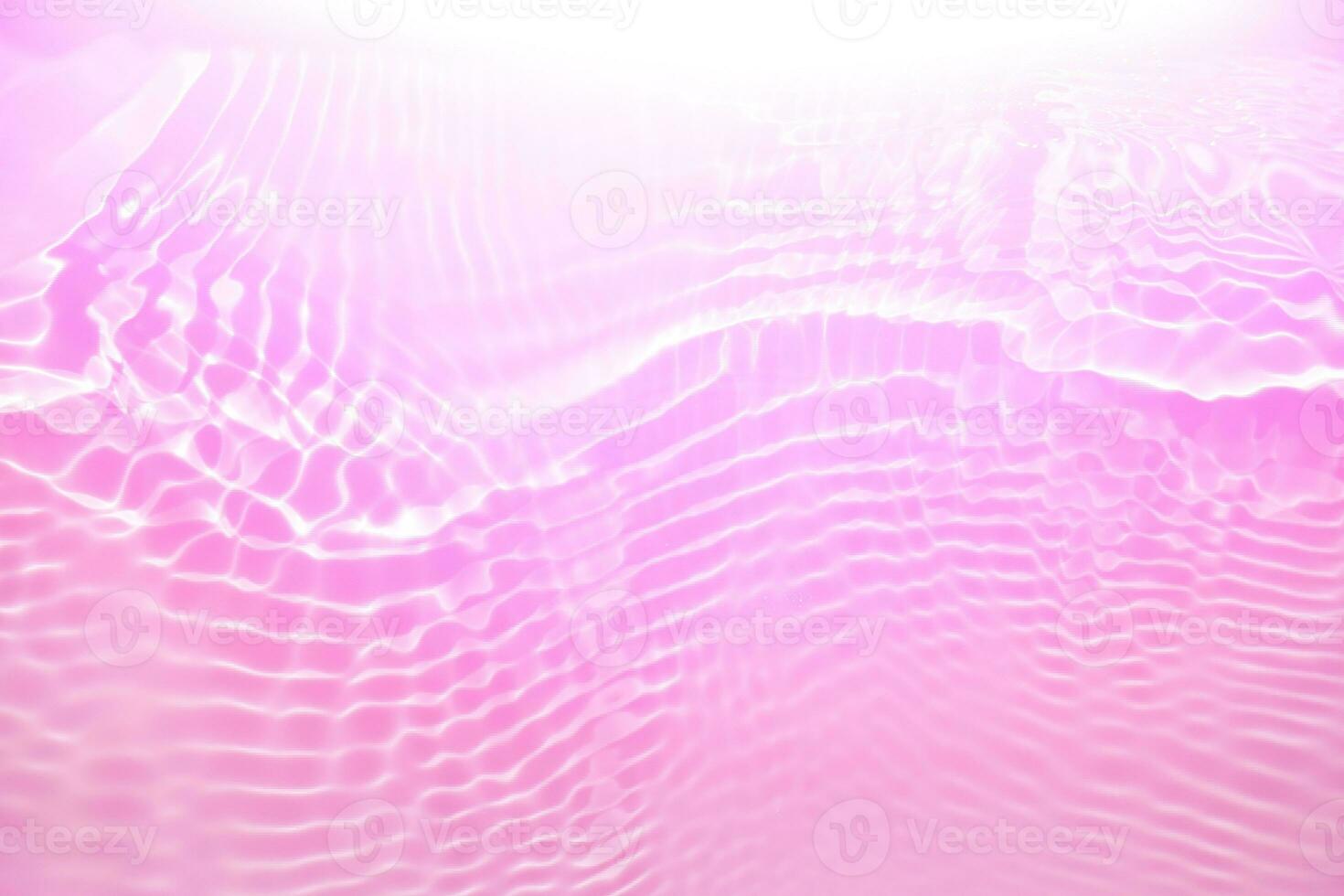 Purple water with ripples on the surface. Defocus blurred transparent pink colored clear calm water surface texture with splashes and bubbles. Water waves with shining pattern texture background photo