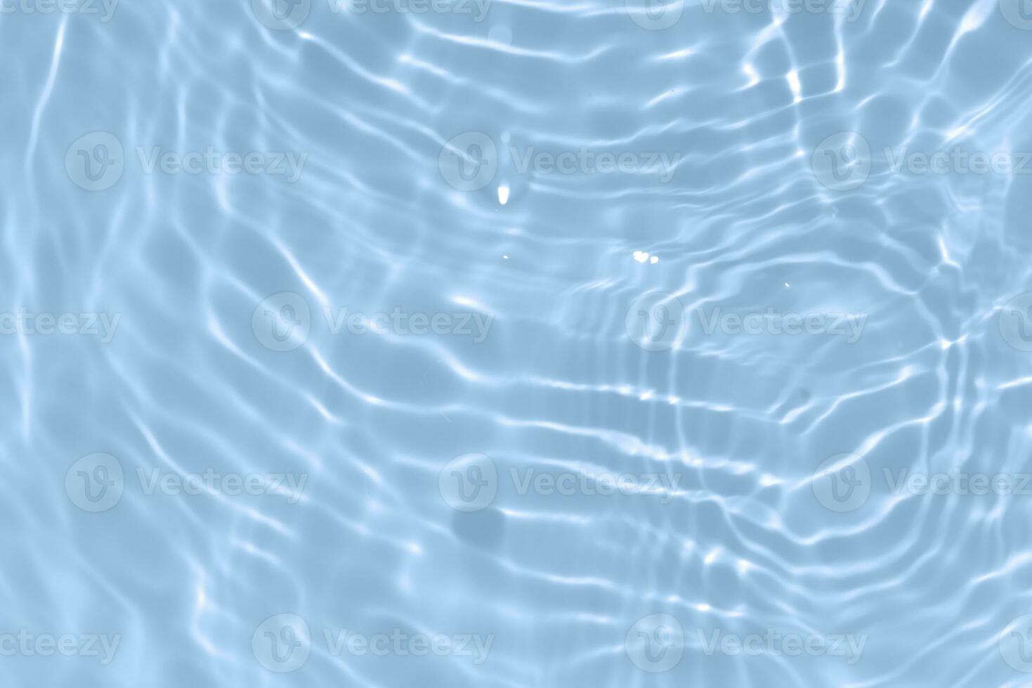 Blue water with ripples on the surface. Defocus blurred transparent blue colored clear calm water surface texture with splashes and bubbles. Water waves with shining pattern texture background. photo