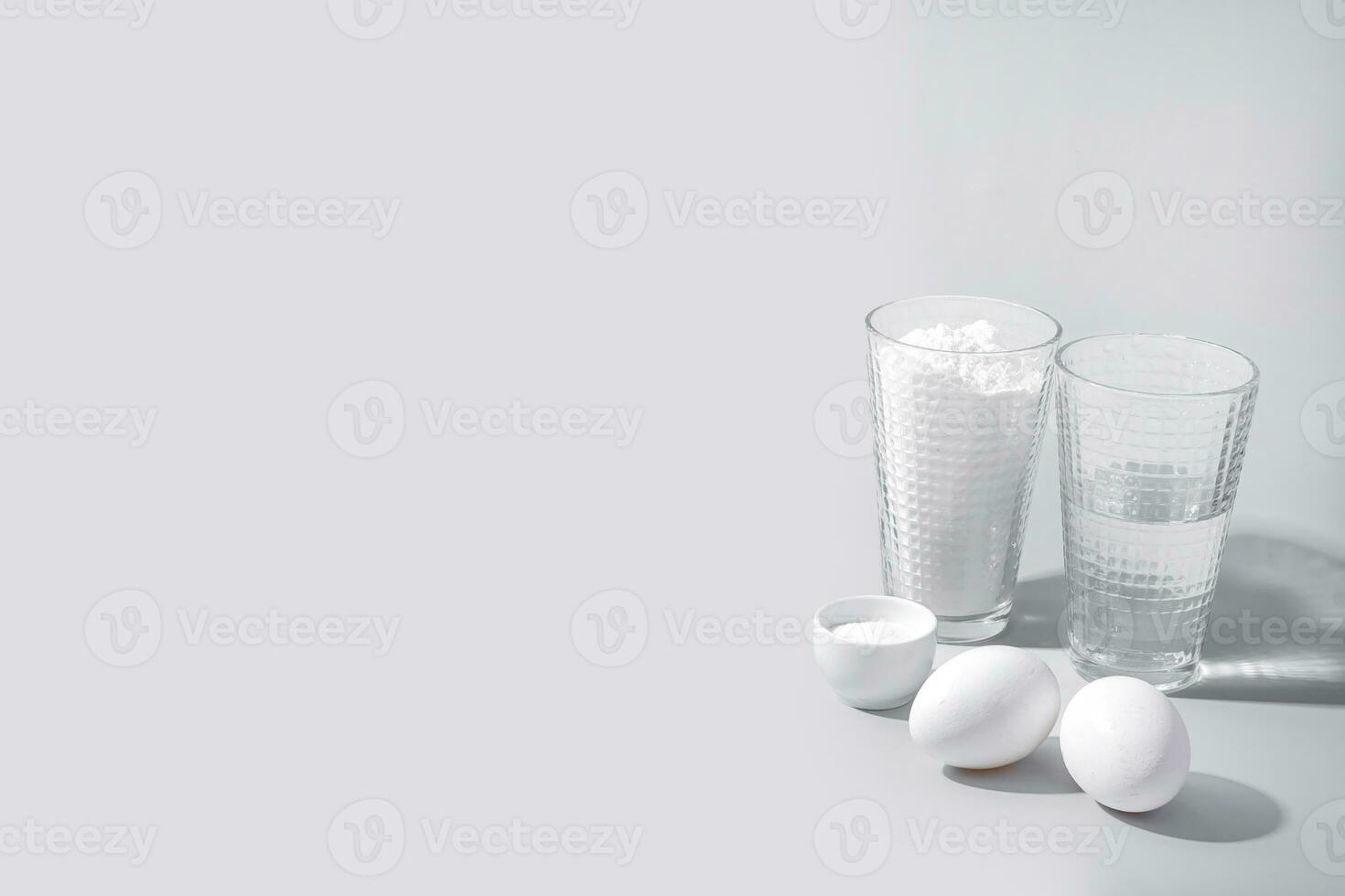 Eggs and milk in a glass raw ingredients for cooking on a grey background. Copy space photo