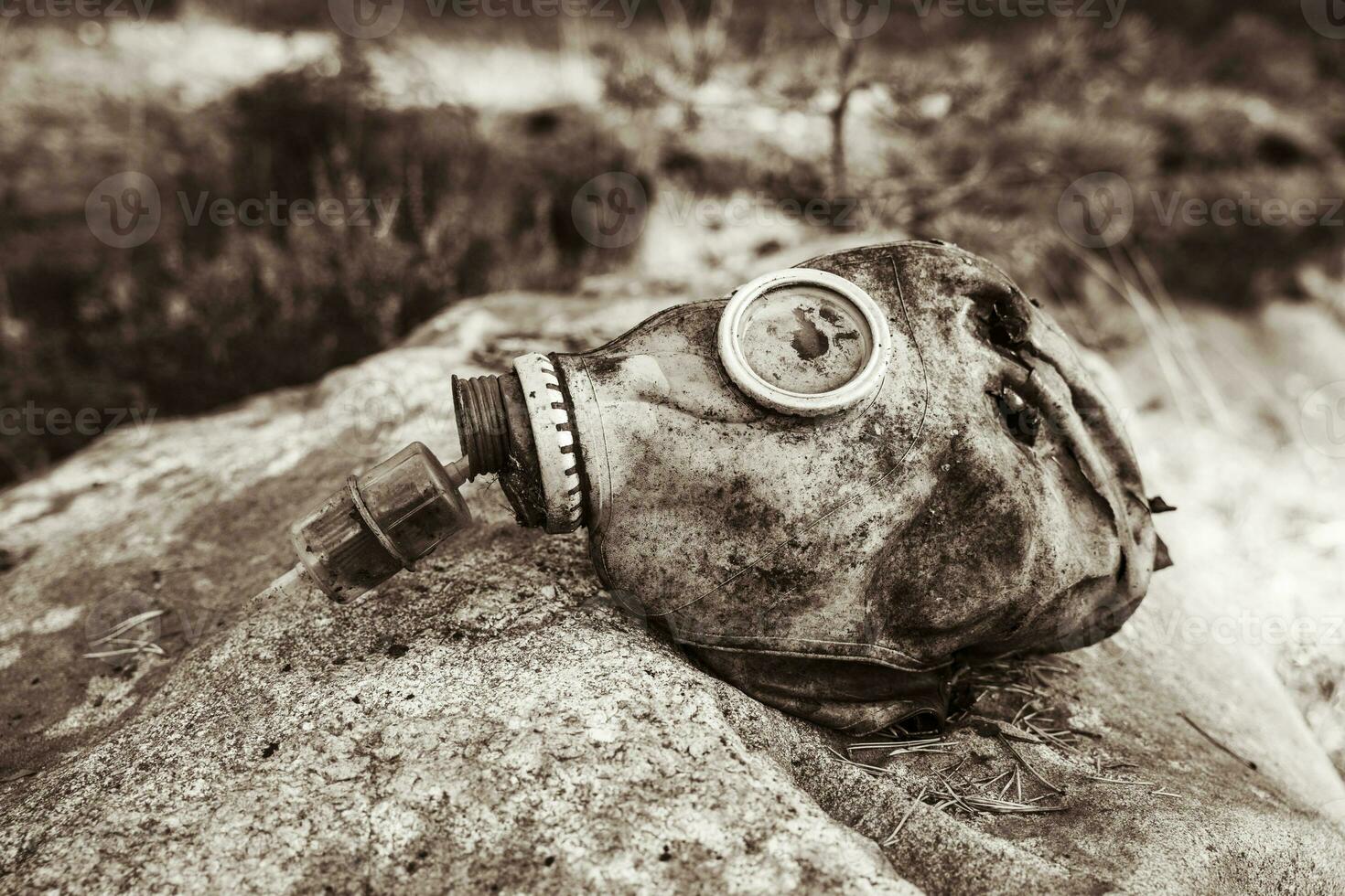 un antiguo usado gas máscara acostado en un grande Roca foto
