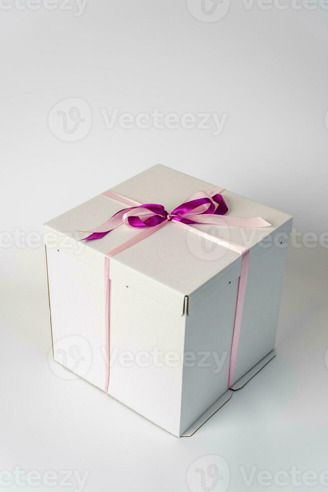 large white gift box tied with a red ribbon on a white background photo