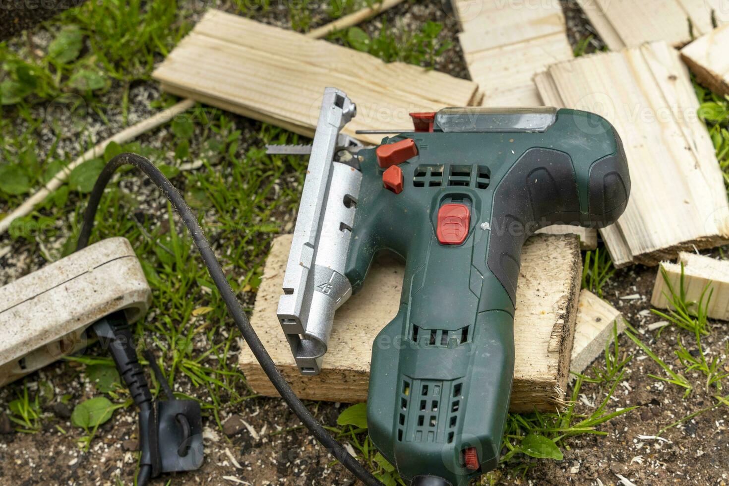 Electric jigsaw. Woodworking power tools. Wooden boards. Workshop. photo