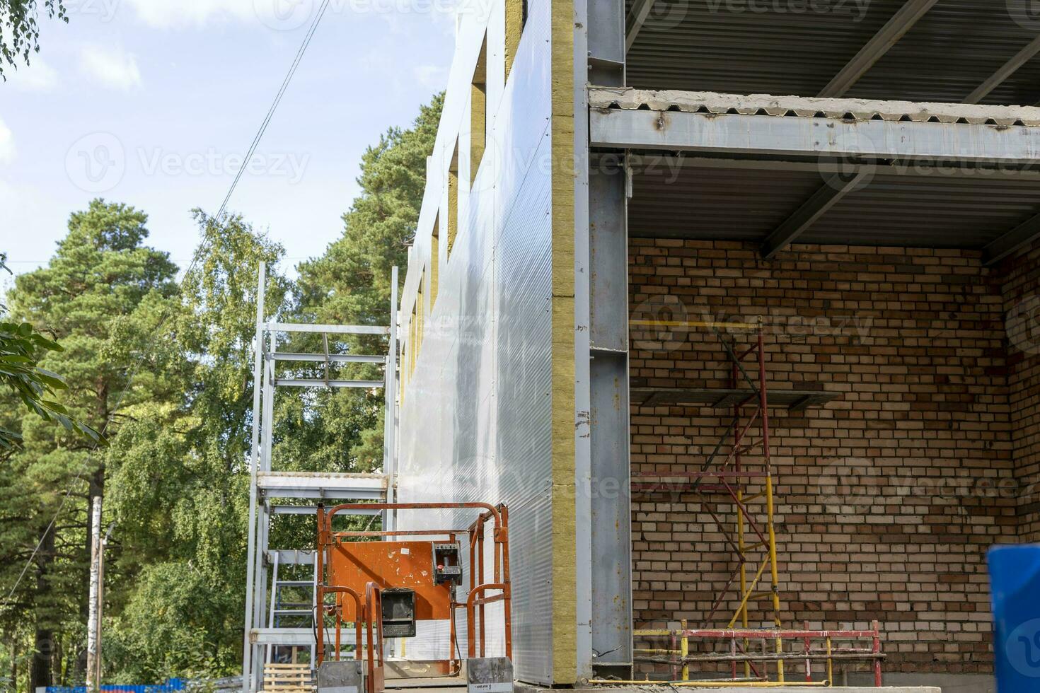 The metal frame of the new building with insulation and sandwich panels photo