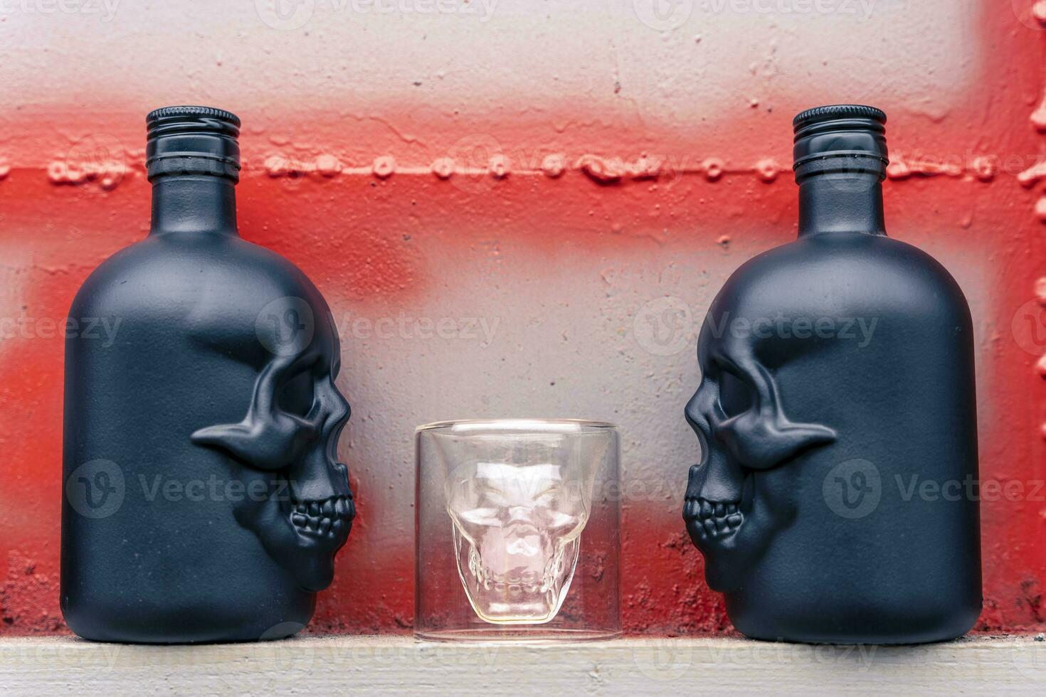 glass gin bottles in the shape of a human skull and a glass stack photo