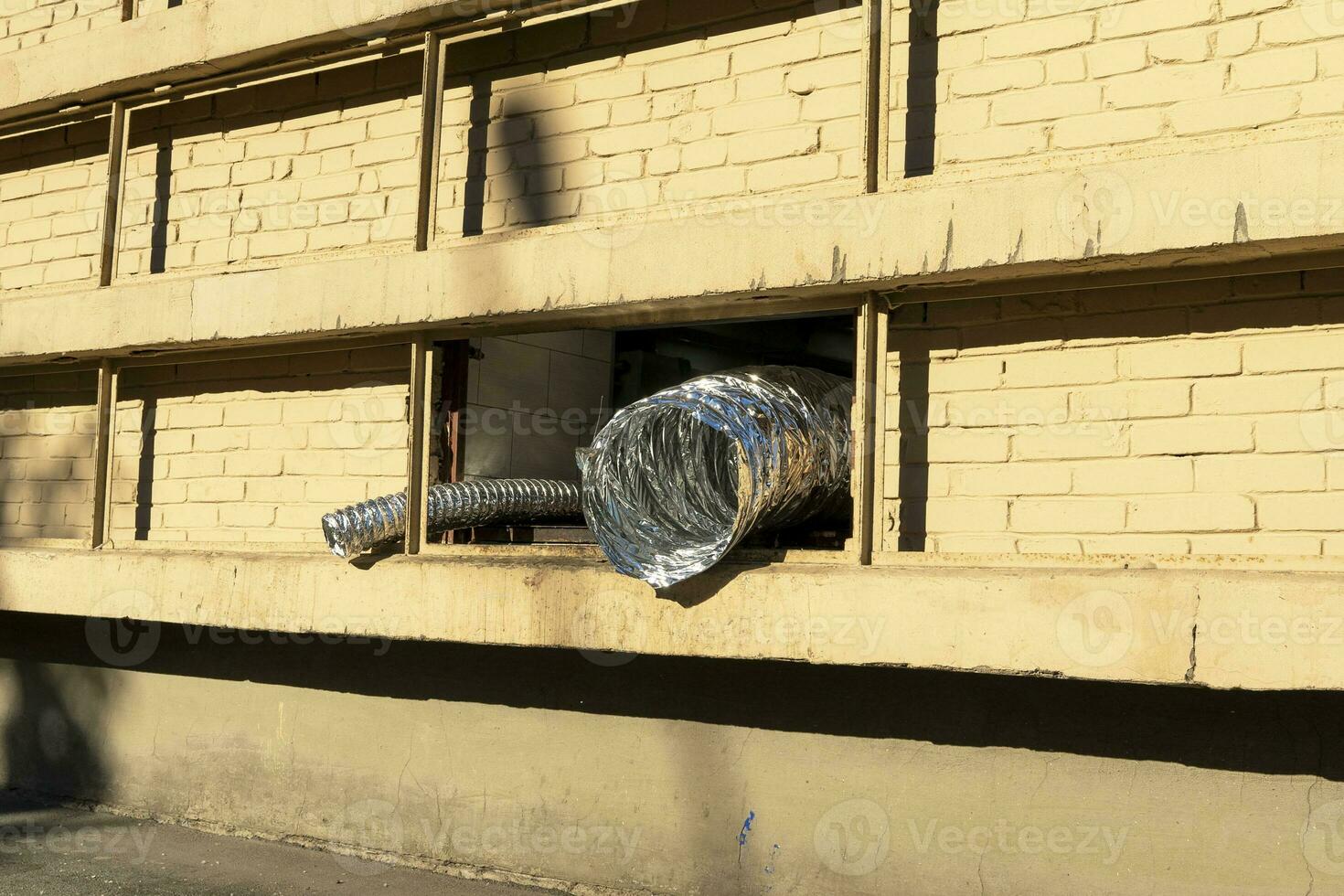 Flexible aluminum foil duct at the window. corrugated exhaust hose photo