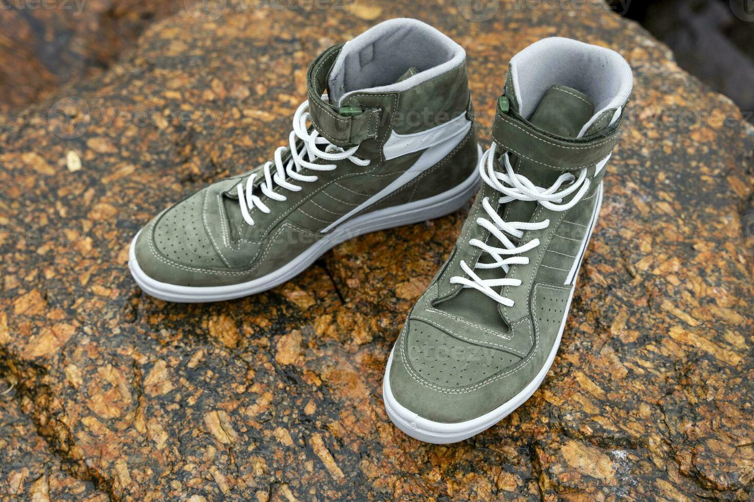 new fashionable high youth sneakers on a stone background photo