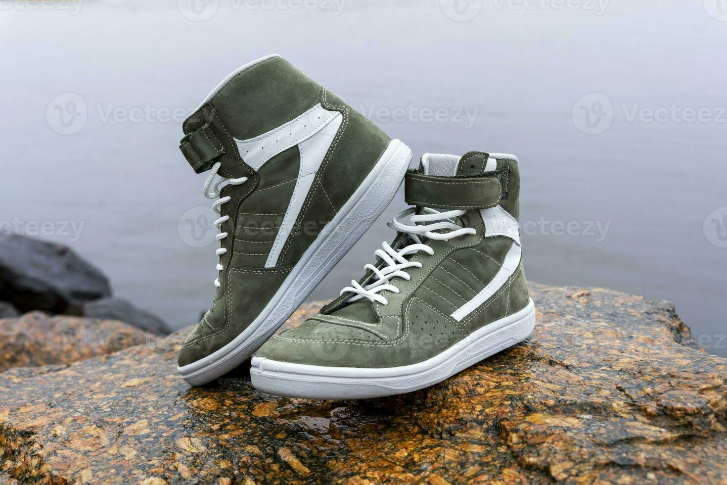 new fashionable high youth sneakers on a stone background photo