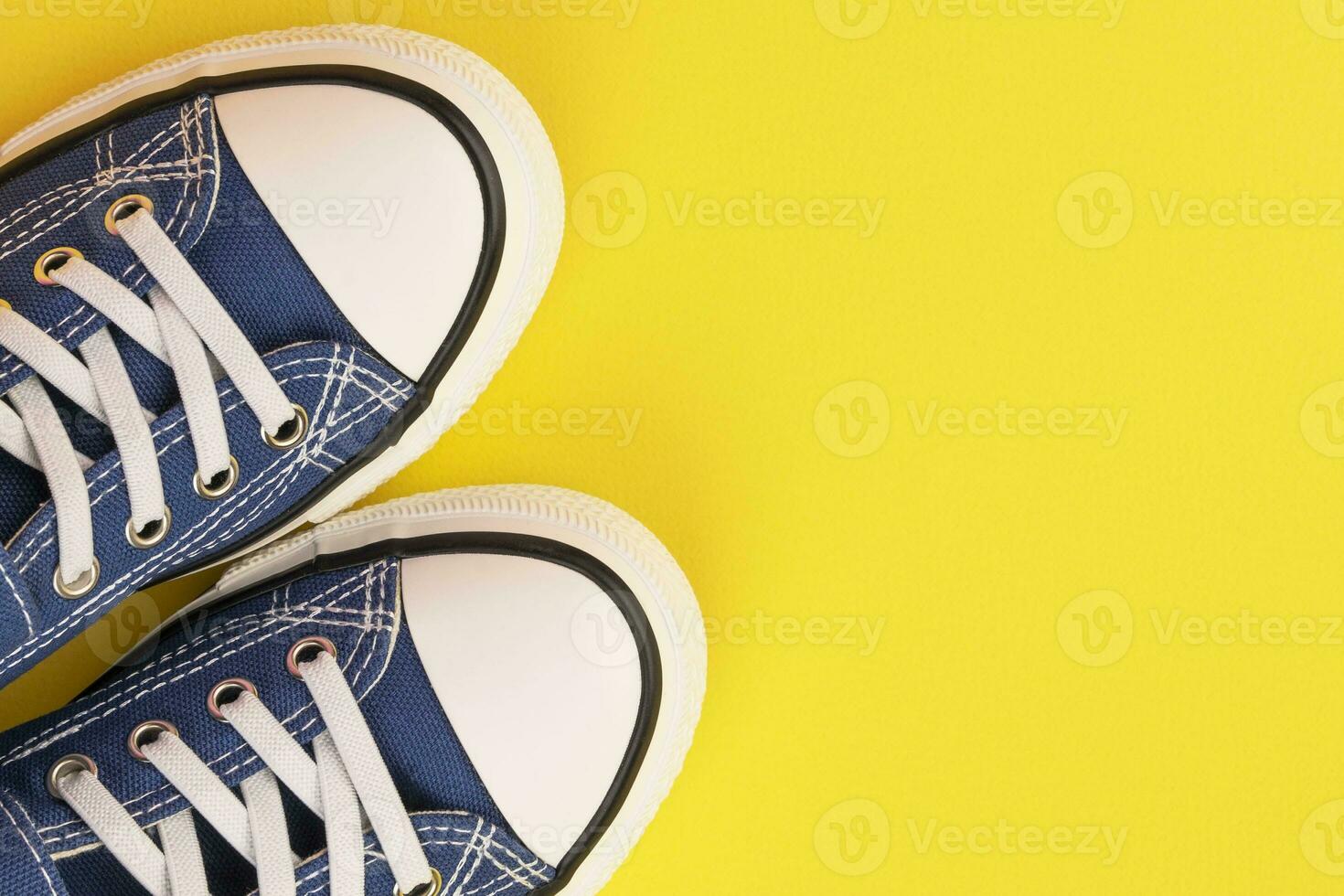 a pair of blue sneakers on a yellow background photo