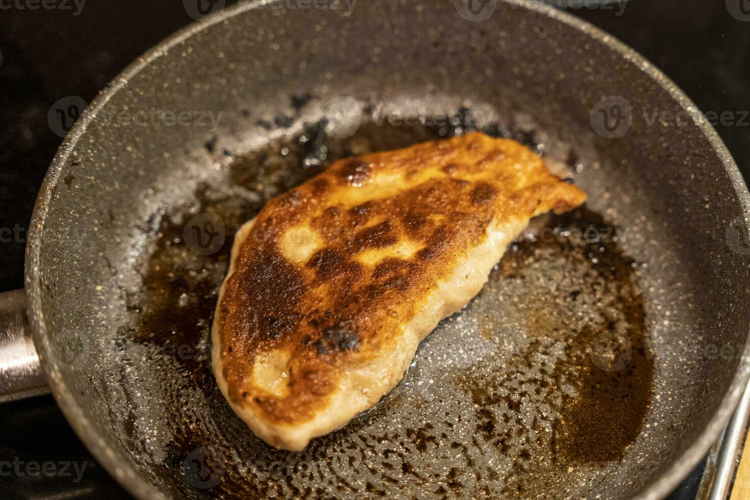 Homemade fried chebureks with meat in a frying pan photo