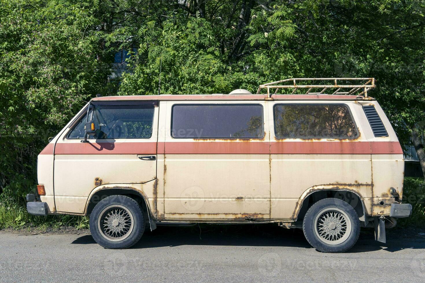 an old vintage rusty minibus standing in the yard. hippie culture photo