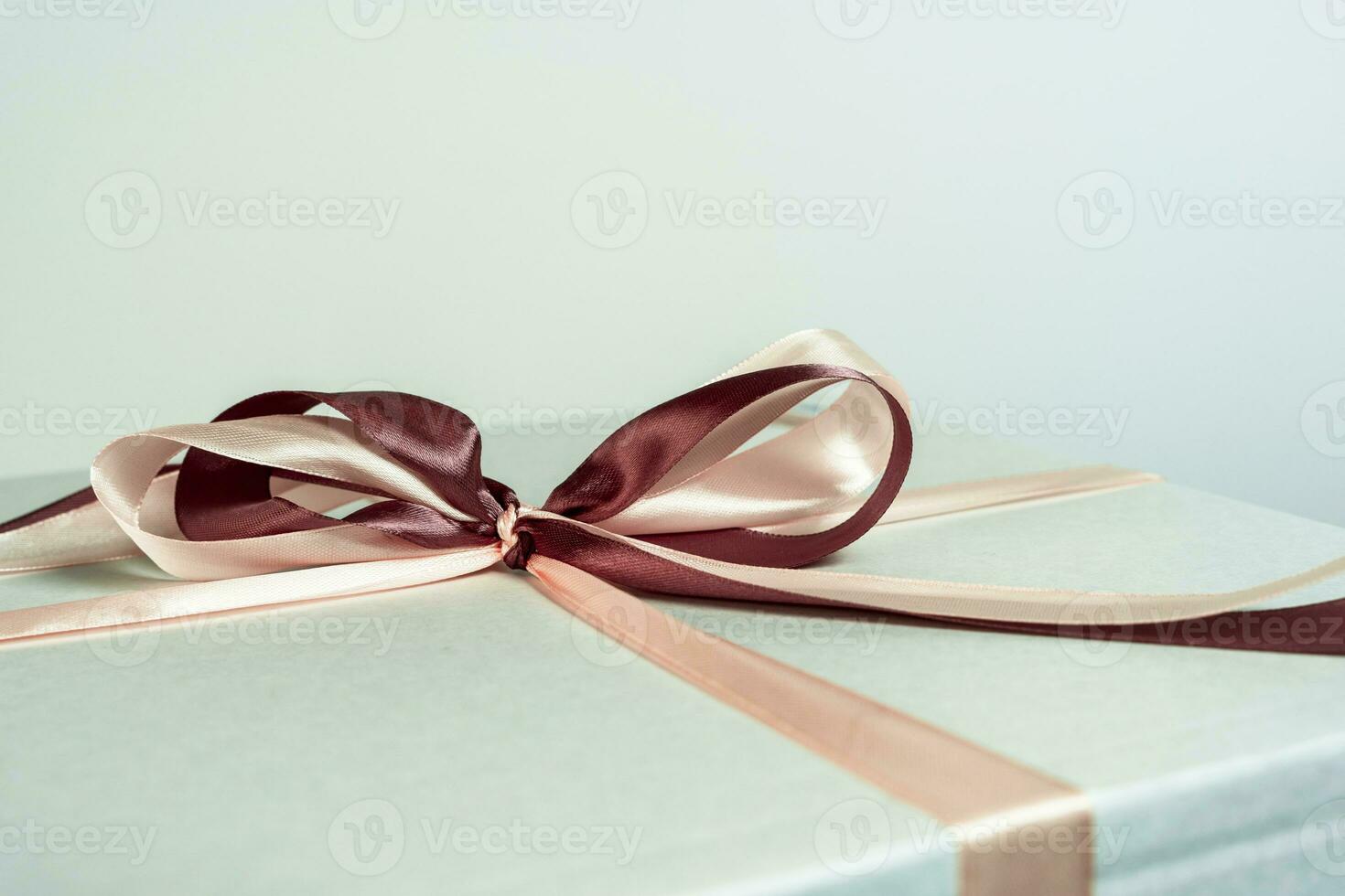 close-up of a red satin ribbon bow on a white gift box photo