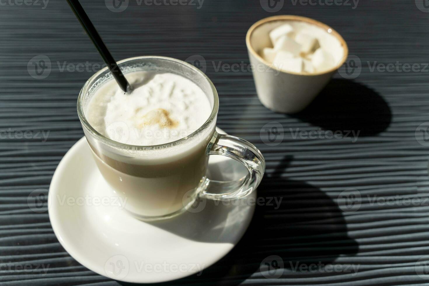 delicious latte coffee in a transparent glass mug on a table in a cafe photo