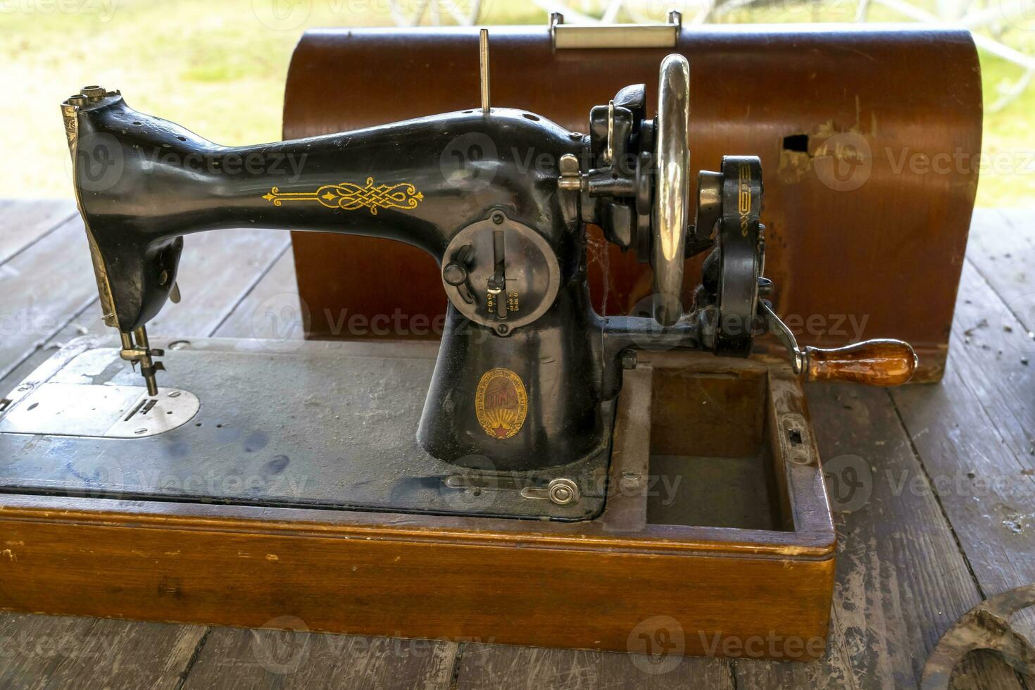 vintage black sewing machine and a hard wooden trunk for its storage photo