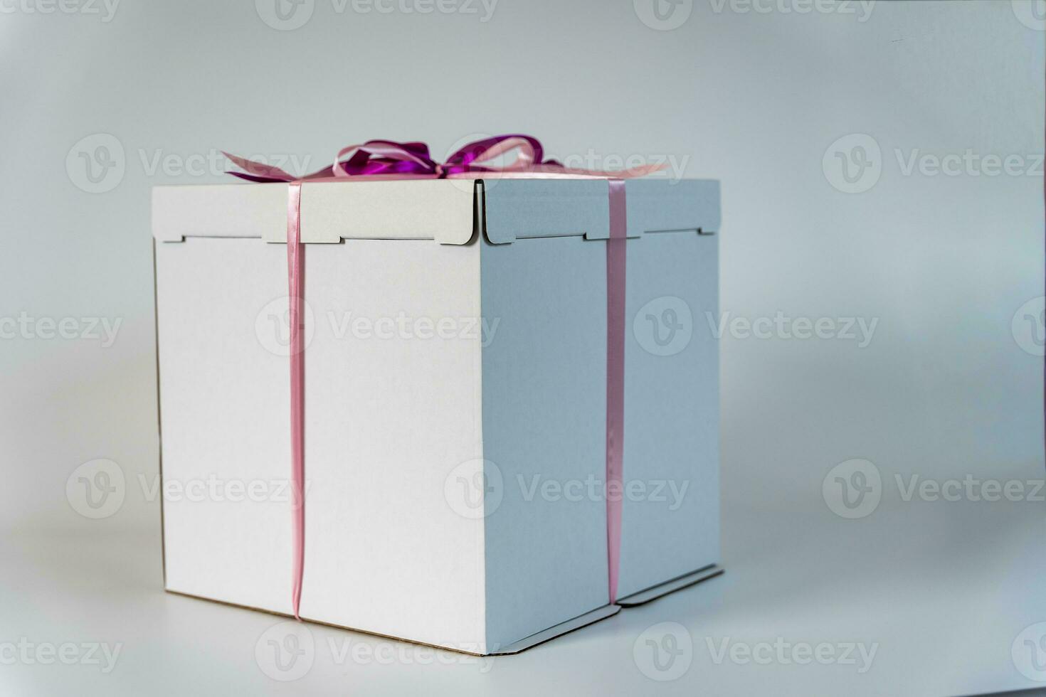 large white gift box tied with a red ribbon on a white background photo